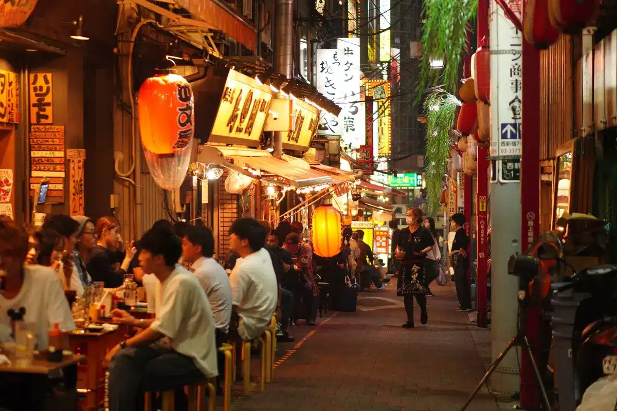 Rue animée avec cafés, bars et restaurants fréquentés par des clients