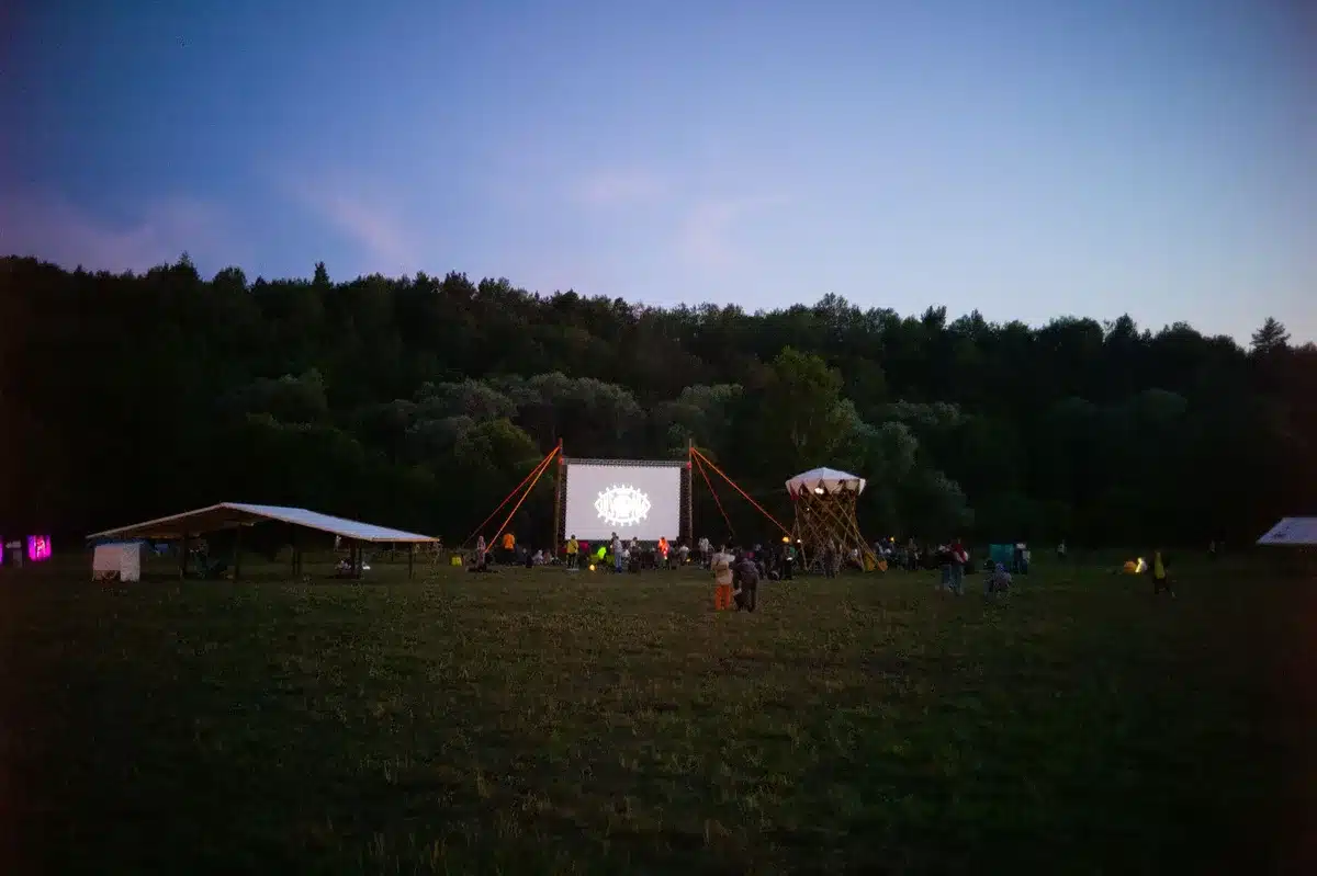 Projection de cinéma en plein air sur la plage au coucher du soleil