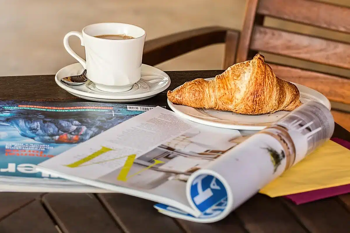 Main anonyme feuilletant un livret municipal posé sur une table